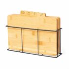 Set of wooden cutting boards with food icons, stored upright in a black metal rack.