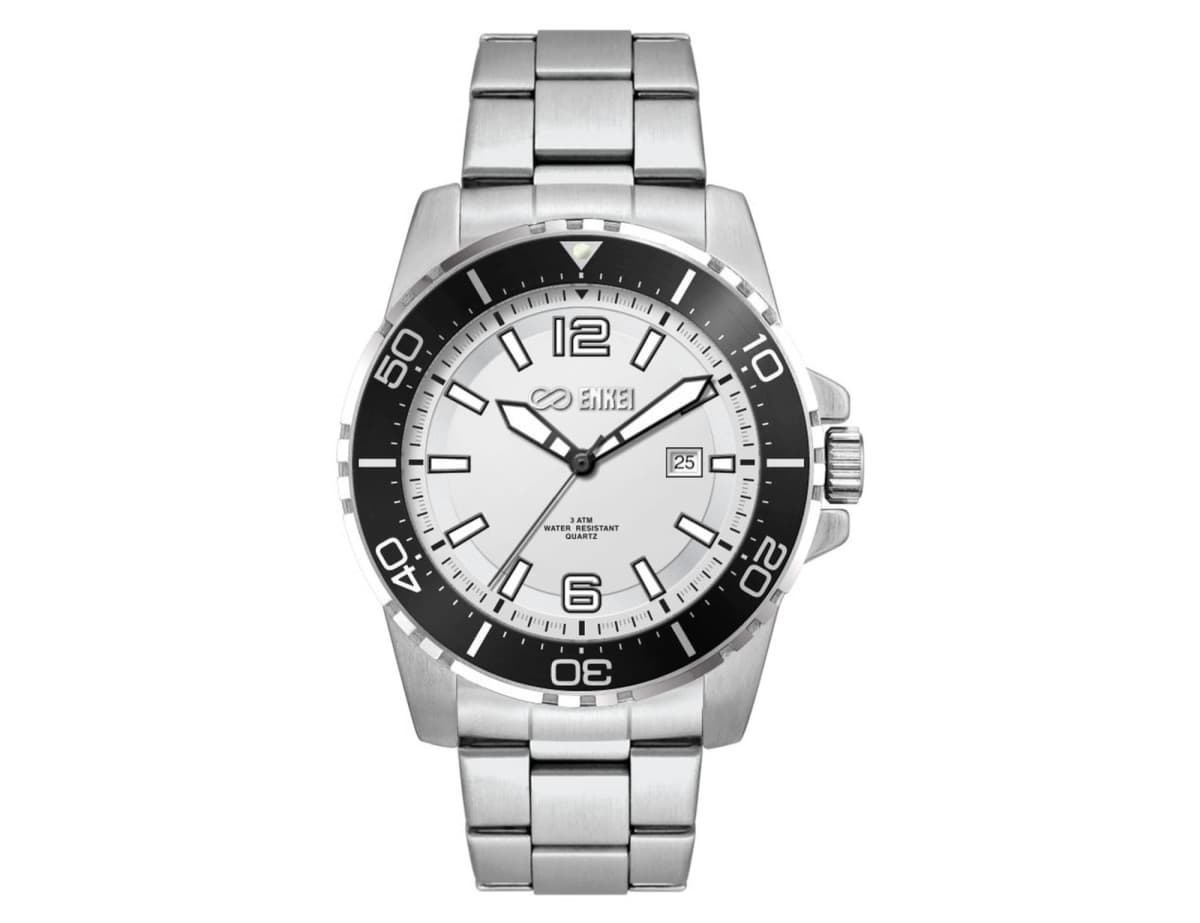 A silver wristwatch with a stainless steel band, featuring a white face and black bezel. It has a date display and luminous markers at the 12, 6, and 9 oclock positions, with a prominent watch brand logo below the 12 oclock marker.