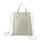 Beige canvas bag with handles and drawstring shoulder straps on a white background.