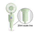 A portable green hand-held misting fan featuring a transparent water container with a marked 20ml scale line. The fan head has a circular design with multiple blades for efficient cooling.