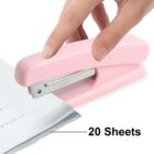 A hand using a pink stapler to staple a stack of papers labeled 20 Sheets on a white background.