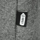 A close-up of a fabric tag on a gray textile surface. The tag is black with a white design featuring an outline of a bottle and the letters RPET inside it. The fabric has a soft, felt-like texture.