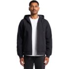 Man wearing a black zip-up hoodie with the hood down, over a white T-shirt and black pants, standing against a plain white background.