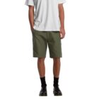 A person wearing a white t-shirt, olive green shorts, black socks, and black shoes, standing against a plain white background. The outfit has a casual and relaxed style.