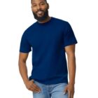 A man with a beard smiles at the camera, wearing a blue T-shirt and light blue jeans.