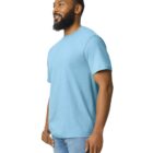 A person with a beard is wearing a light blue T-shirt and blue jeans, standing and looking to the side against a plain white background.