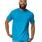 A smiling man with a beard wearing a bright blue T-shirt and jeans stands against a plain white background.