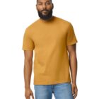 A man with a beard is wearing a mustard yellow t-shirt and blue jeans. He is standing against a plain white background, facing forward.