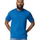 A person with a beard is wearing a plain blue T-shirt and jeans, standing with hands behind their back against a white background.