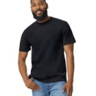 A smiling man with a beard wearing a black T-shirt and blue jeans stands against a plain white background.