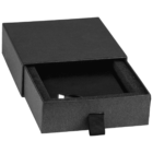 A black rectangular box partially open to reveal a black foam interior. A small black ribbon is attached to the sliding drawer. A USB connector is visible inside the box.