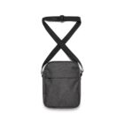 The Flight Two-Tone Bag is a compact, dark gray crossbody with a minimalist style on white. It includes an adjustable black strap and front pocket, ideal for keeping essentials nearby.