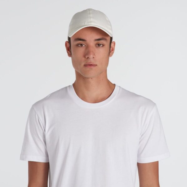 Wearing a white t-shirt and a Davie Six Panel Cap, a person stands against a plain background, facing the camera with a neutral expression.