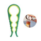 A green and yellow jar opener with a circular grip design, shown next to an image of it being used to open a jar of sauce.