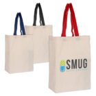 Three tote bags with colored handles are displayed: one with blue handles, another with black, and the third with red. The bag with red handles features the logo and text SMUG Supplements in blue and green.