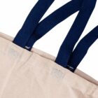 Close-up of a beige fabric bag with three dark blue woven handles attached securely by square stitching with an X pattern. The texture of the fabric is visible, with a focus on the handle attachment details.
