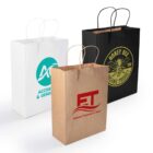 Three paper bags are displayed. The white bag features a blue logo, the black bag has a yellow bee design with Honey Bee Organic Product, and the brown bag shows a red ET logo with Edward Thomson & Sons. Each has matching handles.