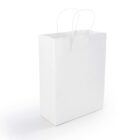 A plain, white paper shopping bag with two white handles stands upright against a light background. The bag is unadorned and reflects a minimalist design.