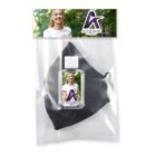 Packaging containing a black face mask and a small bottle of hand sanitizer. The label features a logo and a photo of a smiling person wearing a white shirt.