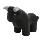A small, black, cartoon-style bull figurine with white horns and simple facial features. The bull stands on four legs, looking forward.