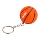 A small orange basketball keychain with black lines and the word BTEC printed on it. The keychain is attached to a metal ring by a short chain.