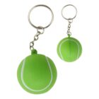 Two green tennis ball keychains with white stripes. Each ball is attached to a silver metal chain and ring, showing a playful and sporty design. The keys are not attached.