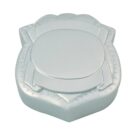 A silver, shield-shaped soap bar with an embossed design, featuring a circular pattern in the center and a border detail. The soap has a smooth, metallic sheen.