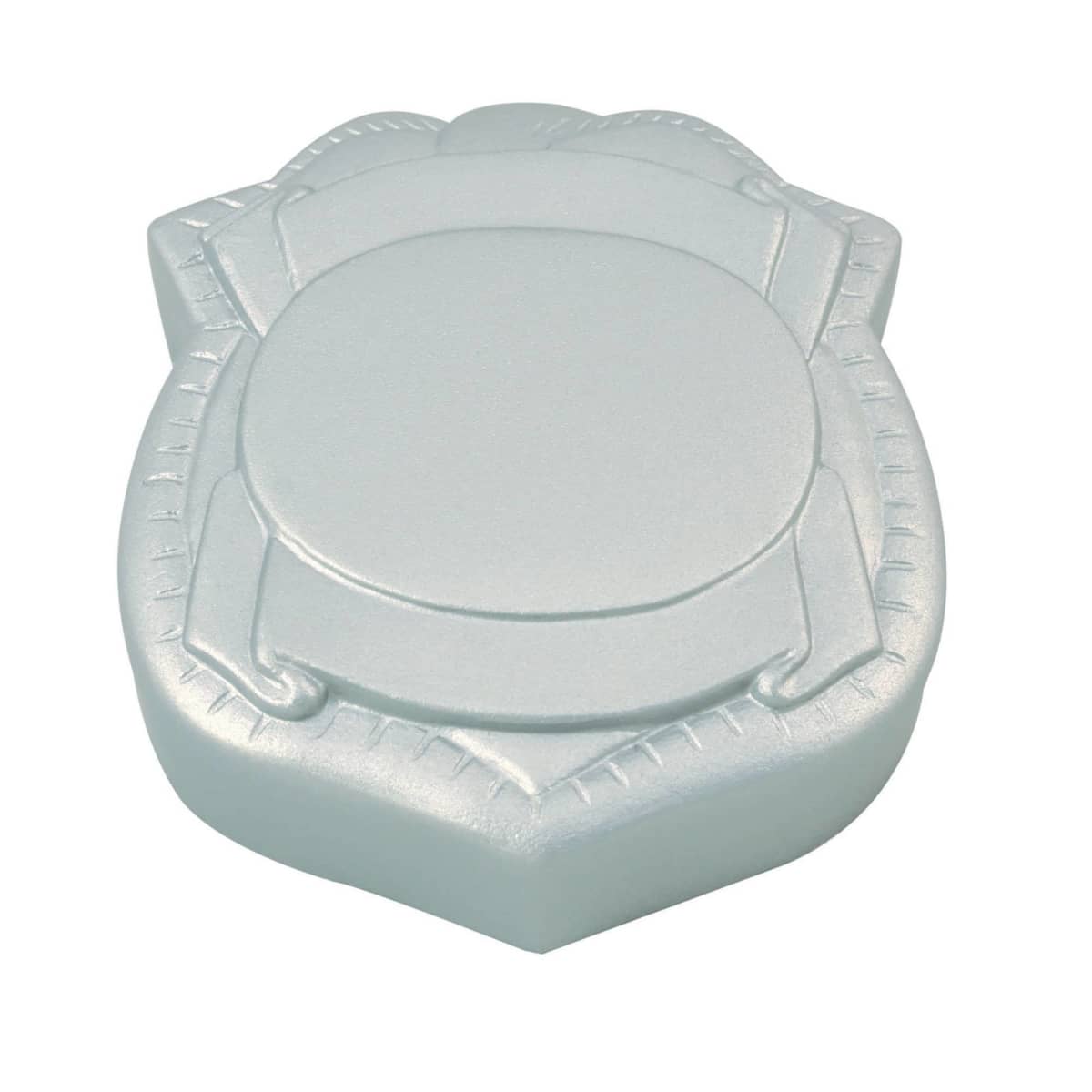 A silver, shield-shaped soap bar with an embossed design, featuring a circular pattern in the center and a border detail. The soap has a smooth, metallic sheen.