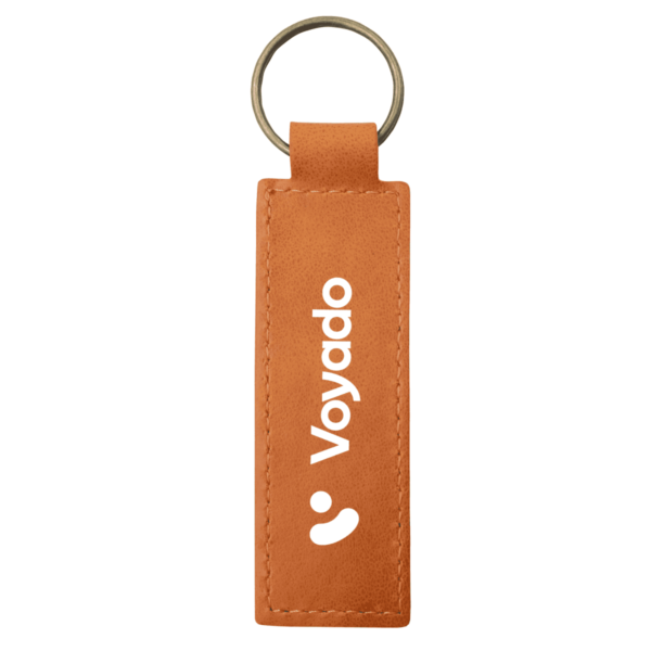 A rectangular, brown leather keychain with a circular metallic ring at the top. The word Voyado is printed vertically in white, with a simple logo featuring a curved line and circle above it.