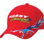 Red baseball cap with HASSY Chassis Modifieds embroidered in white, yellow, and blue letters. Blue and white splash design on the side, adding a dynamic visual effect.