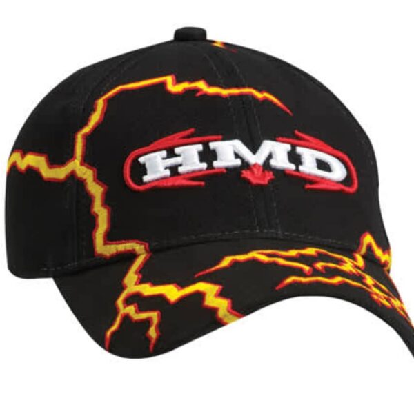 A black baseball cap featuring the text HMD embroidered in white and red with a small red maple leaf. The cap is decorated with bold yellow and orange lightning patterns on the front and brim.