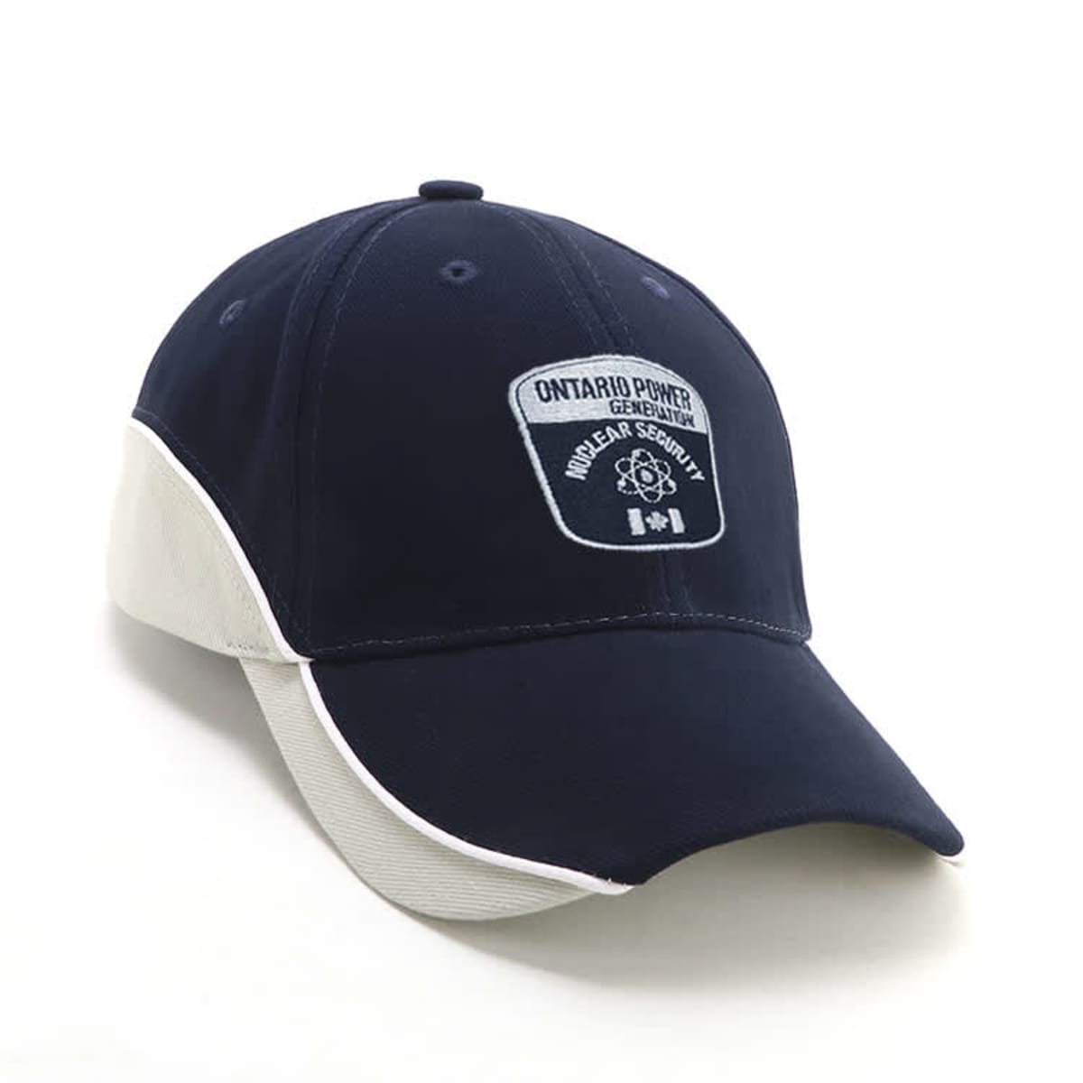A black and white baseball cap with a patch that reads Ontario Power Generation Nuclear Security. The patch also features a symbol and three small icons. The cap is positioned at an angle.