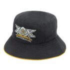 A black bucket hat with a yellow rim, featuring a large embroidered emblem on the front. The emblem includes XX and a crown design, along with text that reads Since 1989.