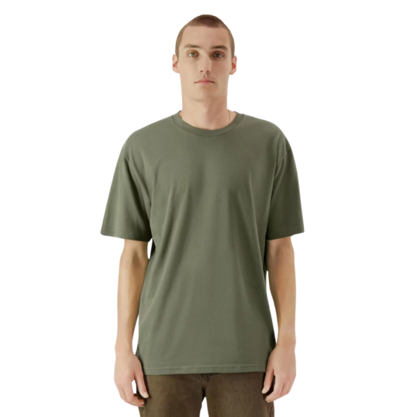 Person in a green American Apparel T-shirt and brown pants stands against a white background.