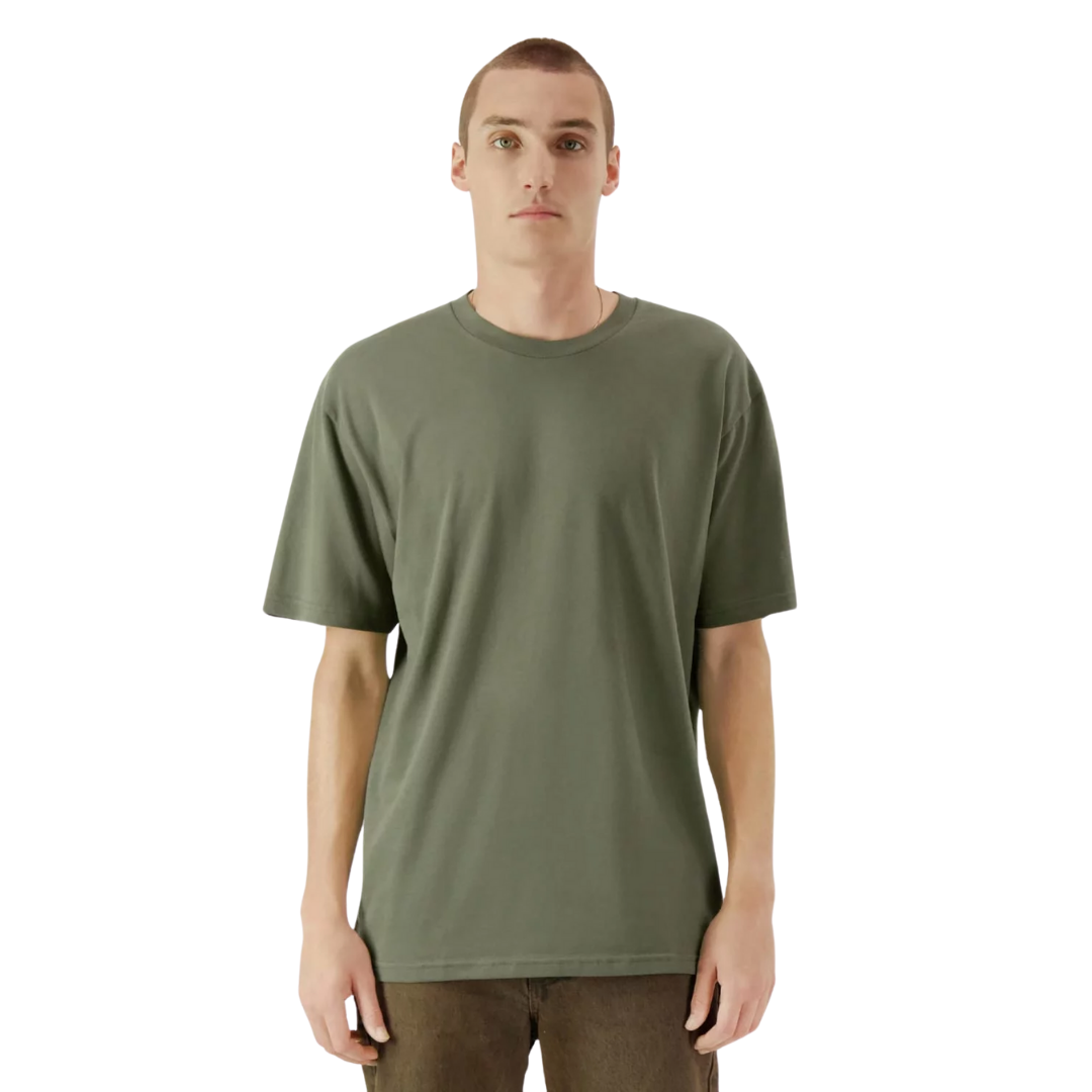 Person in a green American Apparel T-shirt and brown pants stands against a white background.