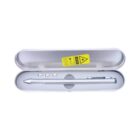 Silver pen with a clip, placed inside a gray metal box with a transparent lid. The box has a yellow warning label. Three small silver objects are also inside the box above the pen.