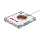 A transparent wireless charging pad with a visible copper coil and a connected white cable. The brand name Harper is printed in red on the surface.