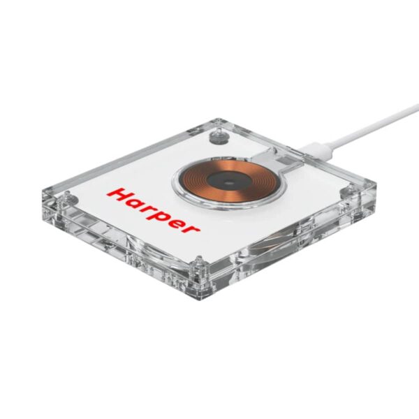 A square wireless charging pad with a transparent casing and a visible copper coil. The word Harper is printed in red on the surface. A white cable is connected to the pad.
