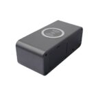 A sleek, rectangular black device with a wireless charging symbol on top. It has rounded edges and appears to have compartments or slots on one side.
