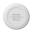 A round, white wireless charger is shown from above. It displays technical specifications in the center including input and output voltages, supported wattages, and certification logos. The surface is smooth with a subtle gray ring design.