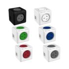 Image of six cube-shaped power outlets in various colors, including black, blue, green, red, and white with gray. Each cube has multiple plug sockets and USB charging ports, arranged in two rows on a white background.