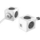 Two white PowerCube outlets are shown, one with a power cord connected. Each cube has multiple socket openings, and one has USB ports. They are designed for versatile power management.