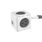 A white cube-shaped power outlet with multiple sockets, including two USB ports on one side and three standard outlets on other sides. A power cord extends from one side of the cube.