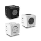 Three power cubes are shown: one black and two white. Each cube has an Australian-style power outlet on top and USB ports on the side. The cubes are designed for electrical extension and charging.