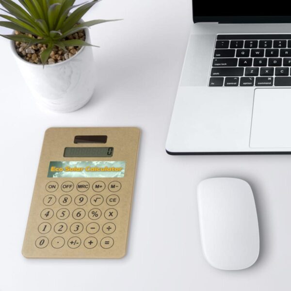 A top view of a desk featuring a laptop, a white mouse, and a cardboard solar calculator titled Eco Solar Calculator. A potted succulent is placed near the upper left corner of the desk.