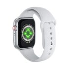 A smartwatch with a silver case and white band is shown. The back of the watch displays a circular green sensor. The side features a red-accented crown and an elongated button. The band has multiple holes for size adjustment.