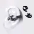 Black wireless earbuds are displayed against a light background. One earbud is shown in an ear model, demonstrating its fit, while the other is positioned beside it.