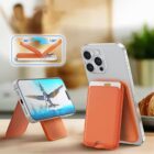 A smartphone with an orange, foldable stand is displayed, positioned both vertically and horizontally. The screen shows an animated bird. A diagram above illustrates the stands 40° to 120° adjustable angles. A croissant is in the background.