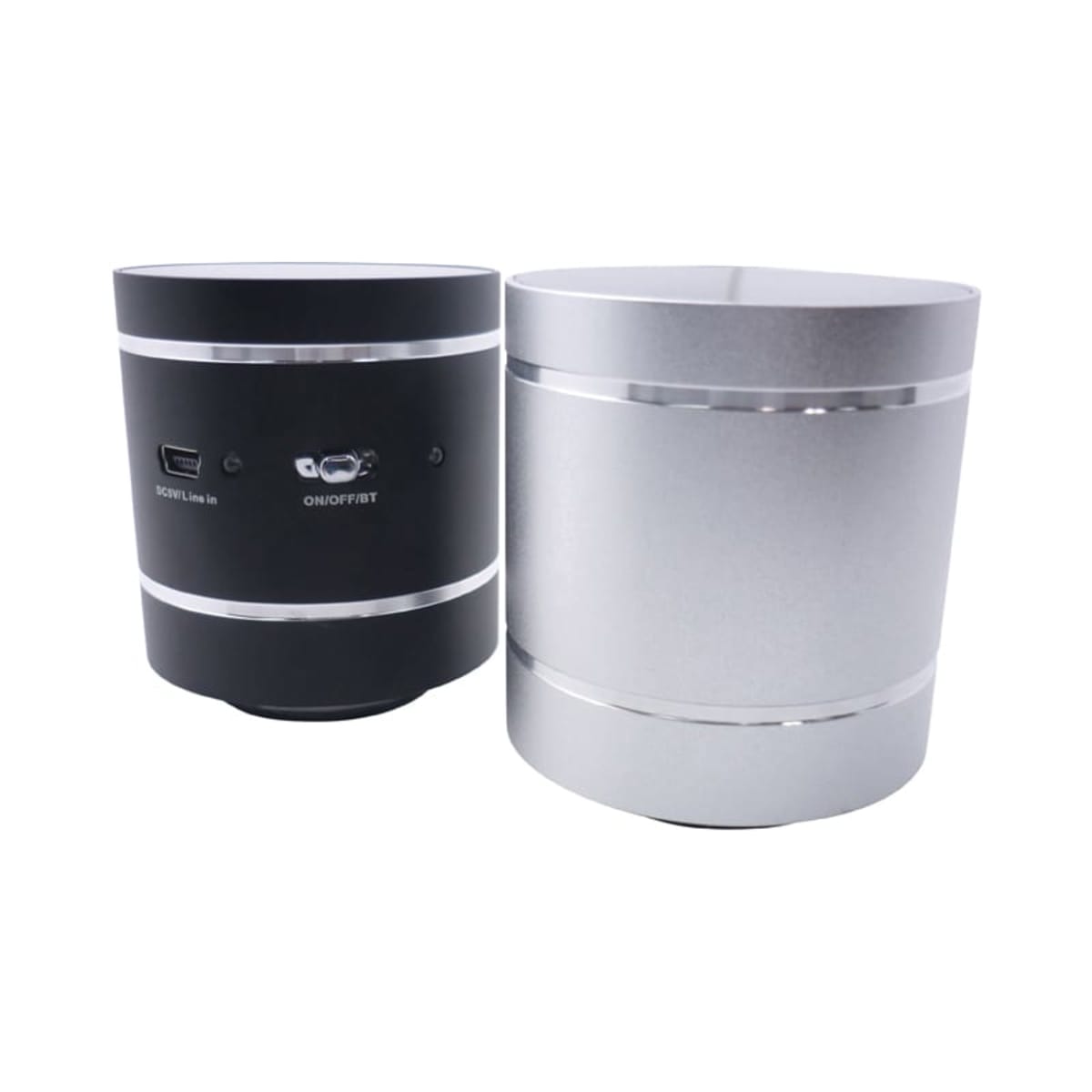 Two cylindrical Bluetooth speakers are shown. One is black with control buttons and a micro USB port on the back, while the other is silver with a smooth surface. Both have metallic bands near the top and base.