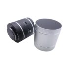 Two wireless Bluetooth speakers are placed side by side on a white background. One speaker is black, showcasing its ports and controls, while the other is silver, displaying a smooth surface. Both are cylindrical in shape.